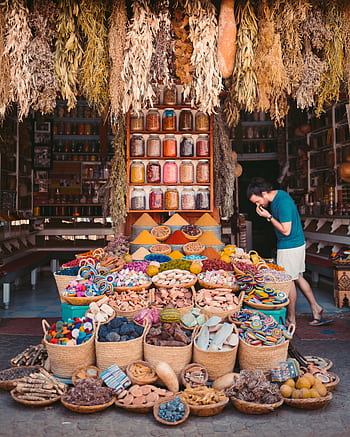 Vibrant display of spices and goods in a Marrakesh street market showcasing Moroccan culture. HD phone wallpaper