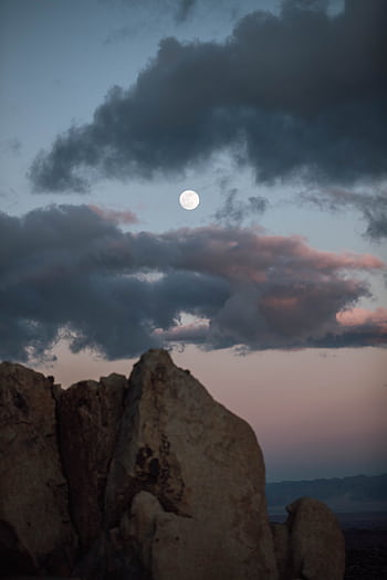 Full moon illuminates rocky formations under a dramatic twilight sky in the California desert. HD phone wallpaper