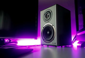 High-quality speaker setup with vibrant purple lighting in a modern studio setting. HD wallpaper