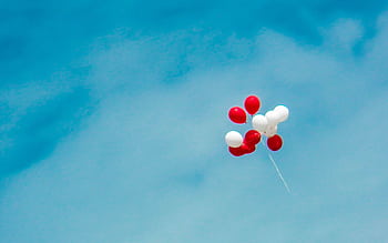 Vibrant red and white balloons float ly in the blue sky, symbolizing dom. HD wallpaper