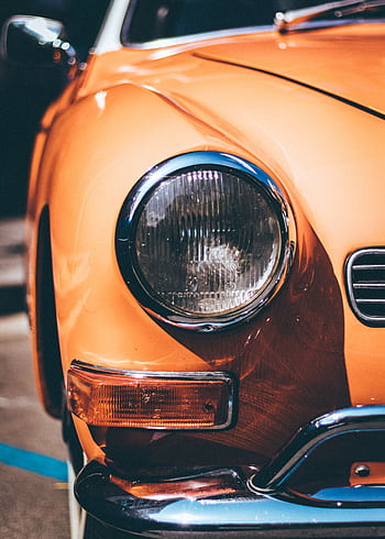 Detailed close-up of a classic orange car headlight reflecting sunlight, captured in Barcelona. HD phone wallpaper