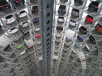 A vertical view of a spiral multi-storey car park filled with vehicles. HD wallpaper
