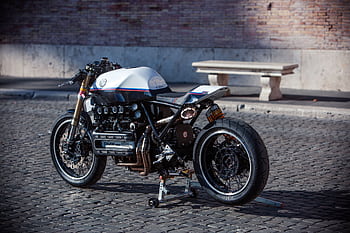 Classic vintage cafe racer motorcycle parked on cobblestone street, Rome, Italy. HD wallpaper