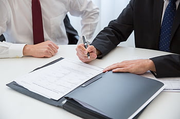 Two professionals signing a contract at a business meeting in an office. HD wallpaper