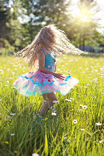 A care young girl dancing in a sunlit meadow filled with daisies. HD phone wallpaper