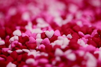 Close-up of pink and red heart-shaped candy sprinkles, perfect for Valentine's Day themes. HD wallpaper