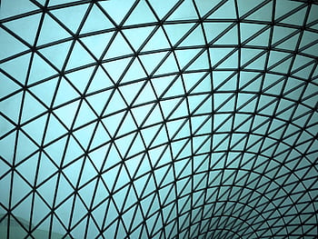 Modern geometric glass ceiling displaying intricate architectural design with a blue tint. HD wallpaper