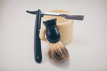 Still life of barber tools including a straight razor, shaving brush, and mug. HD wallpaper