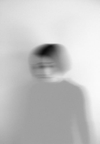 Artistic blurred grayscale portrait capturing motion and emotion. HD phone wallpaper