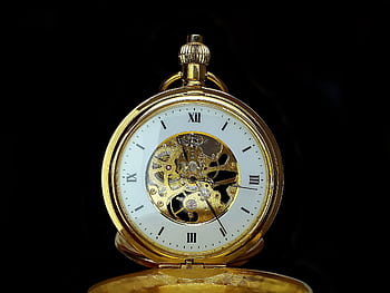 Detailed close-up of a vintage gold mechanical pocket watch on a black background, showcasing gears and roman numerals. HD wallpaper