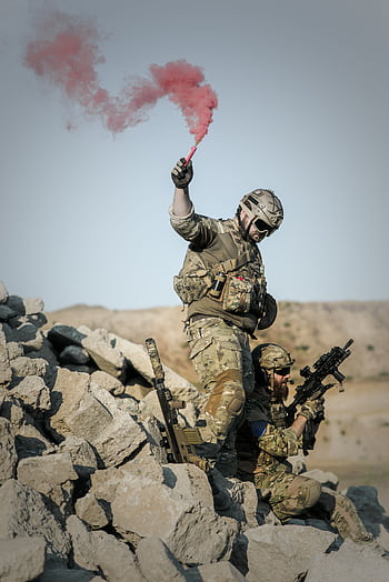 Soldiers in camouflage conduct a military operation using a red smoke signal. HD phone wallpaper