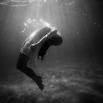 A woman underwater in a dramatic, black and white graphic capture, embodying grace and mystery. HD phone wallpaper