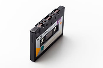 A classic retro cassette tape isolated on a white backdrop, representing 90s music technology. HD wallpaper