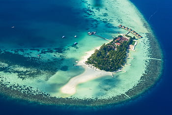 Stunning aerial graph showcasing a tropical island paradise in the clear waters of the Maldives. HD wallpaper
