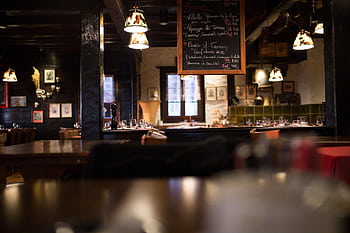 Warm and inviting interior design of a vintage-style restaurant with wooden furnishings and dim lighting. HD wallpaper