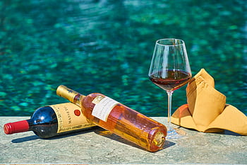 Sophisticated wine setting by the pool, perfect for relaxation and celebration. HD wallpaper