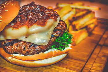 Mouth-watering cheeseburger topped with onions and served with crispy fries. HD wallpaper