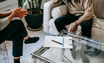 Close-up of a therapy session in an office with two unrecognizable people discussing on a sofa. HD wallpaper