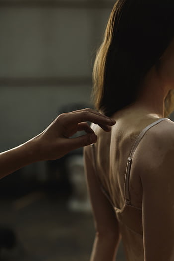 A delicate moment capturing a woman's back in lingerie with soft lighting. HD phone wallpaper