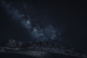 Majestic view of the Milky Way above rugged mountain ranges under a starry sky. HD wallpaper