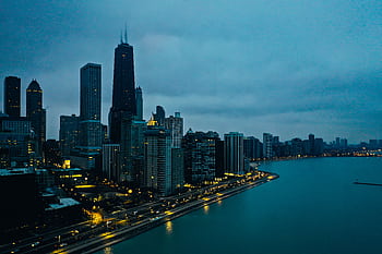 Stunning aerial view of downtown Chicago skyline at twilight, showcasing illuminated skyscrapers along the waterfront. HD wallpaper