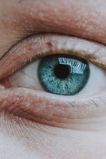 Intricate close-up of a blue eye showing detailed iris patterns and textures. HD phone wallpaper