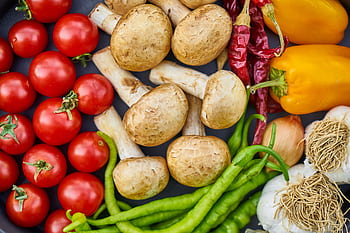 A vibrant assortment of fresh vegetables and mushrooms arranged in a flat lay. HD wallpaper