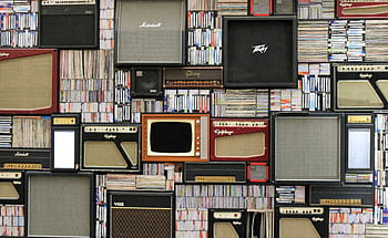 A wall of vintage speakers and TVs surrounded by books and records in a creative display. HD wallpaper