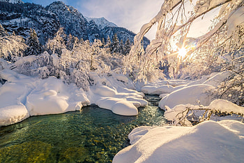 A stream weaves its way through a snowy valley, overlooked by sun-warmed mountains, strems, mountain, quiet, snow, valley, clouds, nature, wilderness, sky, mountains, sun, forest, ice, stream, winter, water, snowy, rocks, icey HD wallpaper
