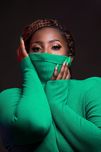 Stunning portrait of a woman with captivating eyes and vibrant green sweater, exuding elegance and style. HD phone wallpaper