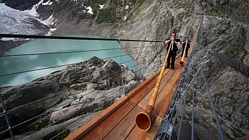 stupendous pedestrian bridge in switzerland, horns, cliffs, players, bridge, lake HD wallpaper