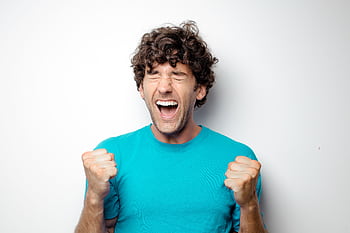 Portrait of a joyful man in a blue shirt celebrating with excitement and closed eyes. HD wallpaper
