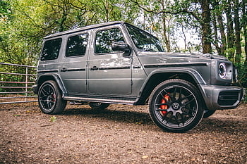 A luxurious Mercedes-Benz SUV parked in a scenic wooded area, showcasing elegance and power. HD wallpaper