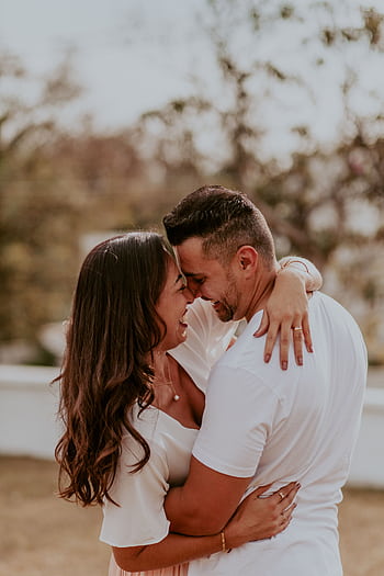 A joyful couple embracing outdoors, capturing intimate and happy moments together in summer. HD phone wallpaper