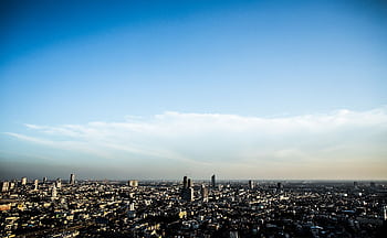 A breathtaking cityscape view showcasing skyscrapers and a vast urban skyline under a clear blue sky. HD wallpaper