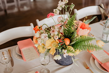 A sophisticated table setting with a vibrant floral centerpiece perfect for weddings or events. HD wallpaper