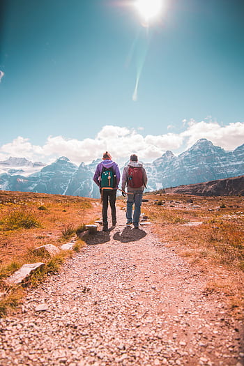 Two hikers walking on a scenic trail in Banff National Park, Alberta. HD phone wallpaper