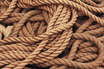 Detailed close-up view of intertwined brown ropes used as ship accessories. HD wallpaper