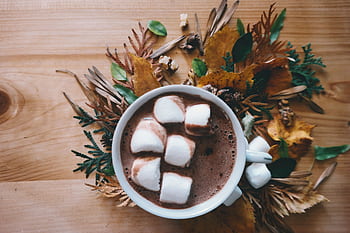 Warm cup of hot chocolate with marshmallows on a wooden table decorated with autumn leaves. HD wallpaper