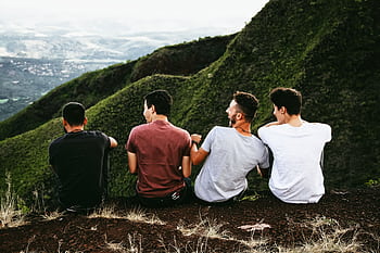 Four friends enjoying a scenic mountain view, symbolizing friendship and adventure. HD wallpaper