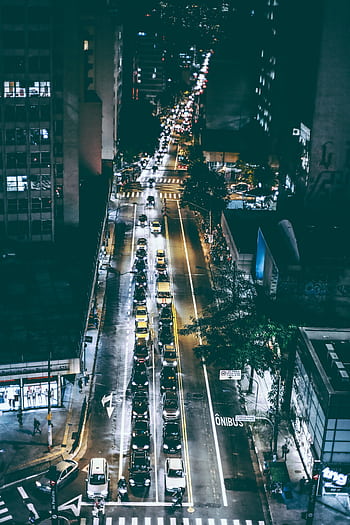 Aerial view of city street at night with vibrant traffic and light trails. HD phone wallpaper
