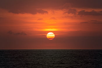 Breathtaking sunset over the ocean with vibrant orange hues and a peaceful seascape view. HD wallpaper