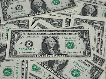 A detailed shot of a pile of U.S. one-dollar bills showcasing currency and finance concepts. HD wallpaper