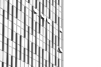 Low angle view of a futuristic skyscraper with geometric glass facade and reflections. HD wallpaper