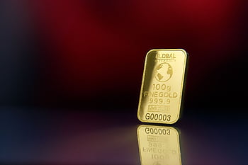 Close-up of a 100g fine gold bar against a red reflective surface, symbolizing wealth and luxury. HD wallpaper