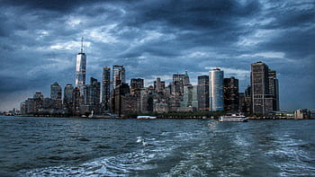 Dramatic view of New York City skyscrapers against a moody twilight sky. HD wallpaper