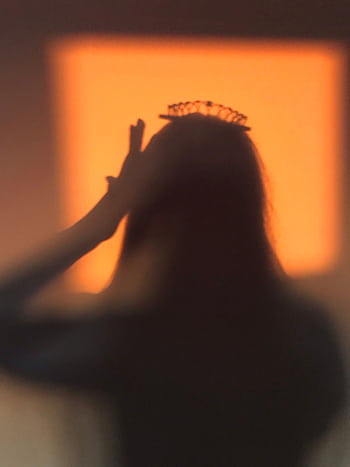 A silhouette of a person wearing a crown with a warm orange background. HD phone wallpaper