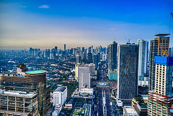 A breathtaking aerial view of Jakarta's urban skyline during the day, showcasing skyscrapers and city life. HD wallpaper