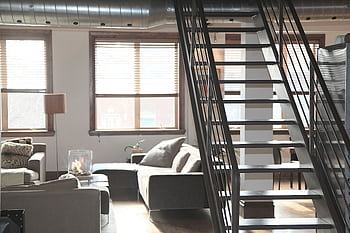 Bright and modern loft interior featuring cozy furniture and industrial elements, perfect for urban living. HD wallpaper