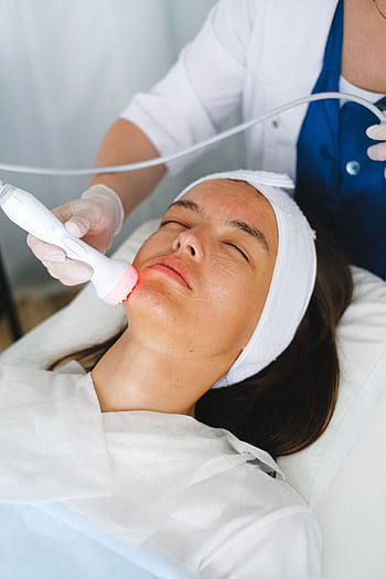 A relaxing facial treatment procedure in a modern spa clinic for skin rejuvenation and wellness. HD phone wallpaper